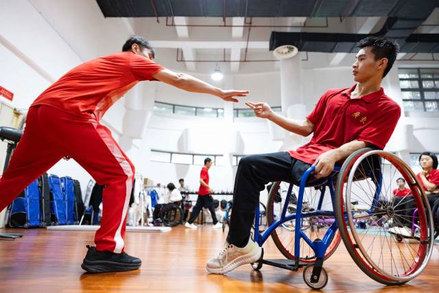 日常训练中，龙杰用手臂的走向指导吴安迪出剑位置。